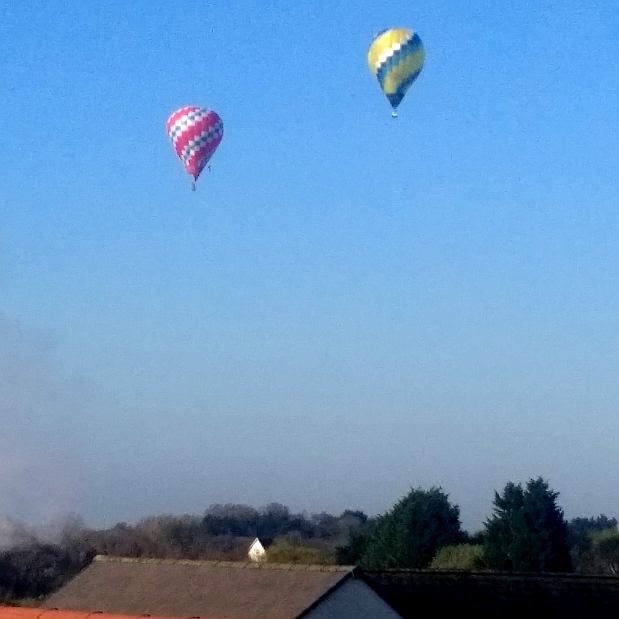 2 hot air balloons in flight over Catshill
